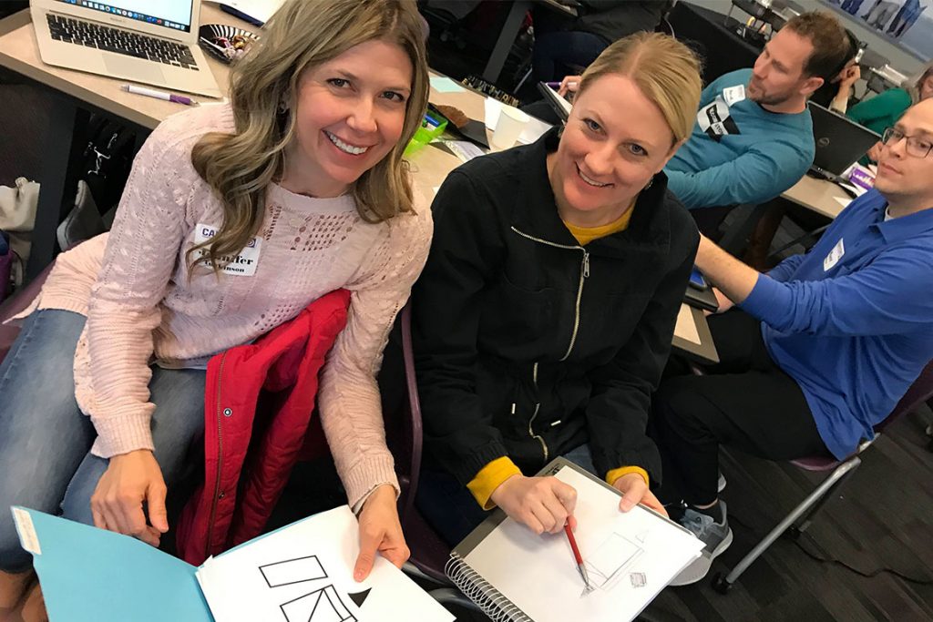 Teachers smiling at in-person professional development training
