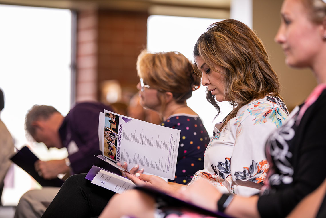 Teachers reading professional development event brochures